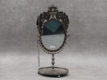 Amé-François JACQUOT       :  Miroir ovale sur pied en acier poli à décor de vases fleuris